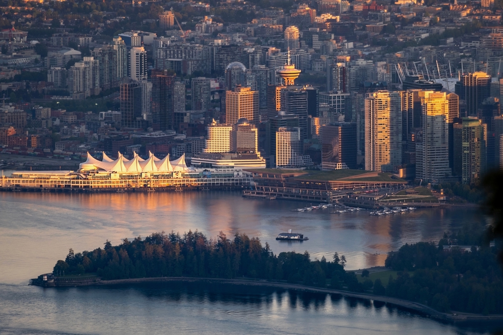 Skyline van Vancouver met Canada Place aan de waterkant in avondlicht.