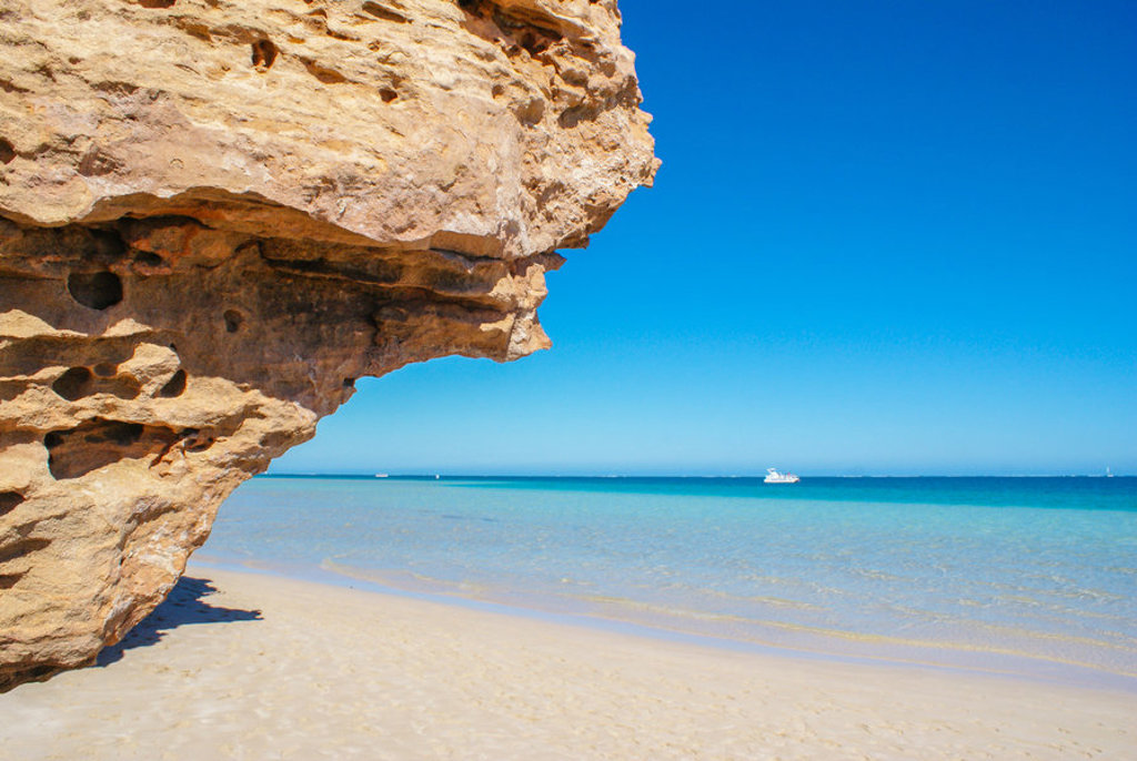 Rotsformatie aan het strand met helderblauw zeewater tijdens een groepsrondreis door West-Australië.
