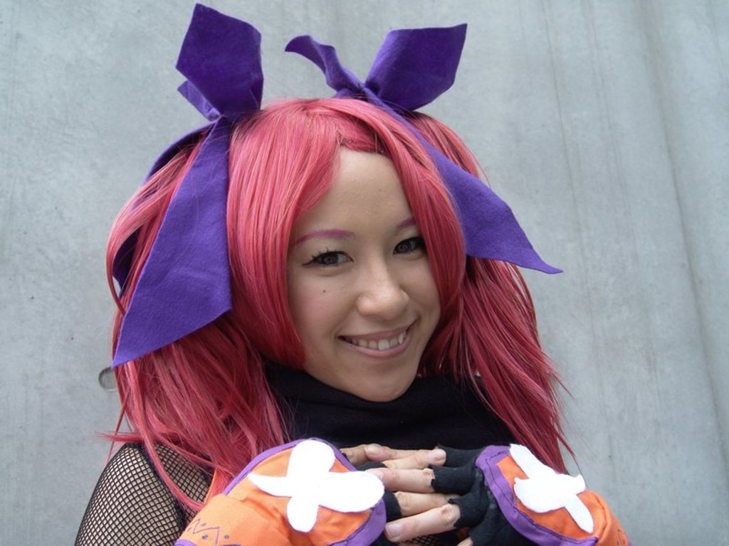 Japanse cosplaydeelnemer met roze haar en paarse strik tijdens groepsrondreis Japan Hoogtepunten.