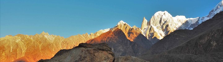 Berglandschap in Pakistan met besneeuwde bergtoppen in het ochtendlicht.