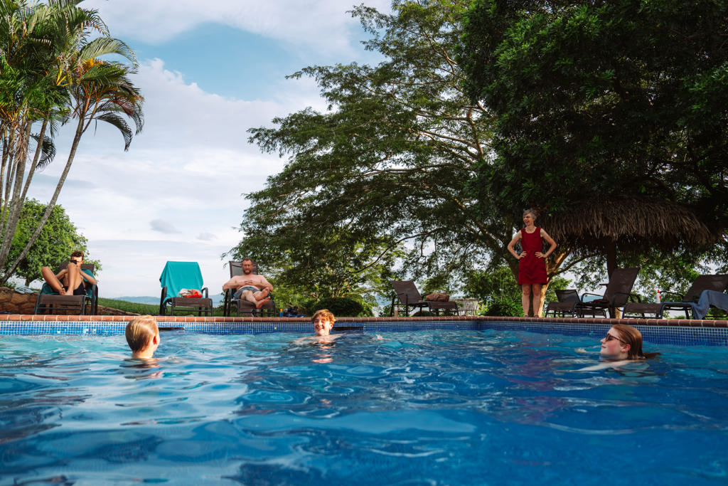 Gezin zwemt in een zwembad bij een lodge in het groene Costa Rica tijdens een familiereis.
