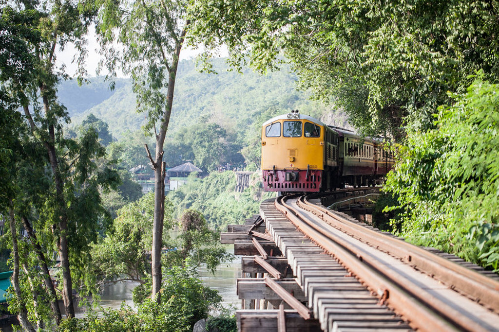 Gele trein op de Death Railway bij de River Kwai, een hoogtepunt van een groepsrondreis Thailand.