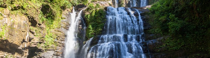 Nauyaca Waterfalls in Costa Rica, watervallen die in een heldere lagune stromen, omringd door tropisch groen.