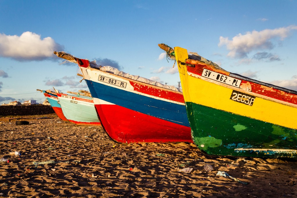 Gekleurde vissersboten op het strand van de Kaapverdische Eilanden bij zonsondergang.