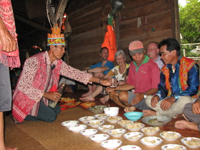 Traditionele ontvangst met lokale drank en maaltijd in een longhouse op de Route Maleisisch Borneo.