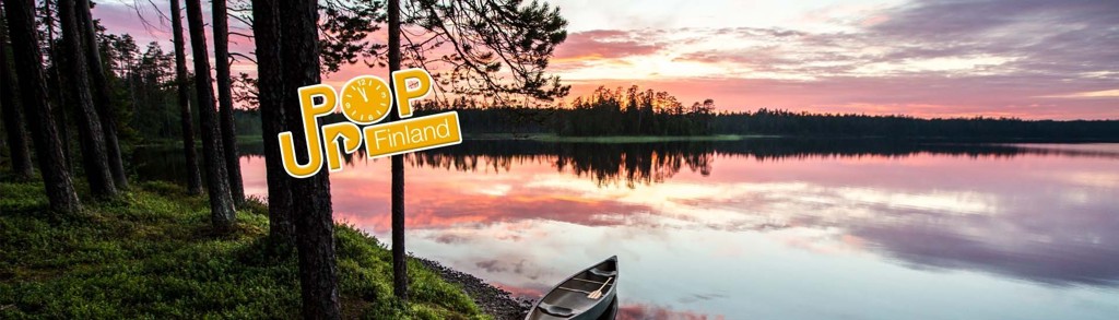 Zomeravond aan een Fins meer in Lapland met kano aan de oever en bos op de achtergrond.