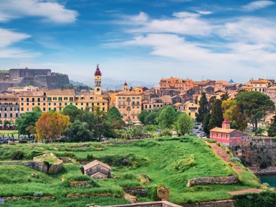 Panorama van Corfu-stad met het Oude Fort en de klokkentoren, gezien vanaf de groene vestingwallen.