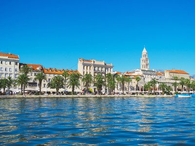 Boulevard en oude stad van Split met palmbomen en de klokkentoren van de kathedraal aan de Adriatische Zee.