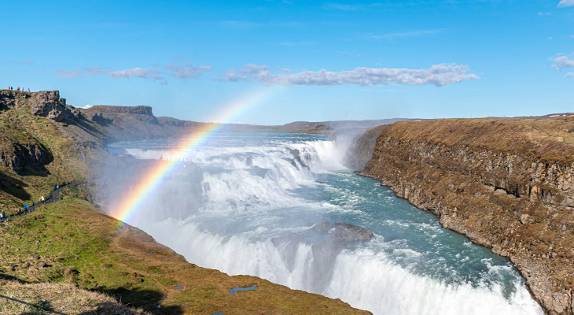 Gullfoss waterval Gullfoss-waterval in IJsland met regenboog boven de kloof en kolkend rivierwater.