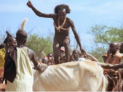 Man springt over een stier tijdens een traditionele ceremonie in Ethiopië.