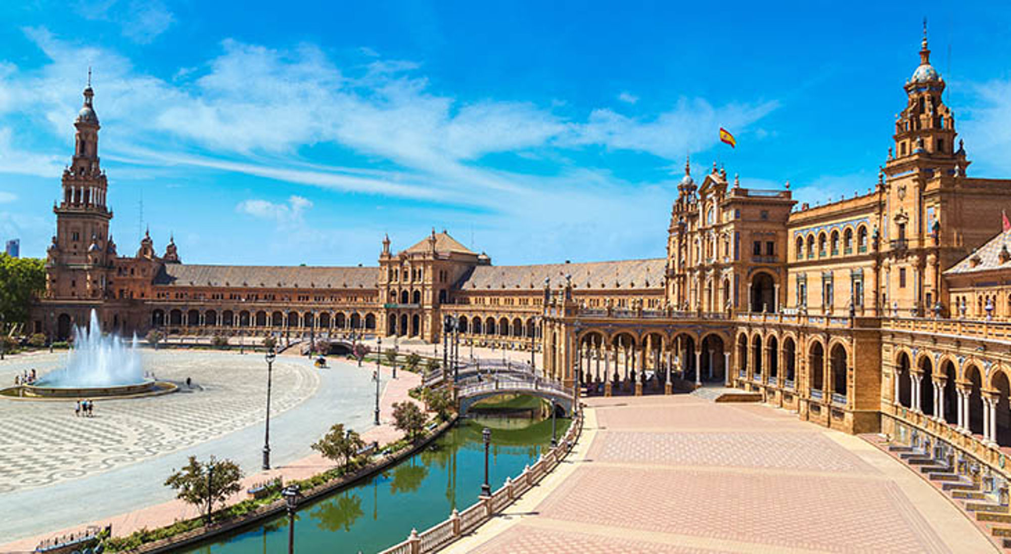 Plaza de España in Sevilla Plaza de España in Sevilla met fontein, kanaal en monumentale gebouwen onder een blauwe lucht.
