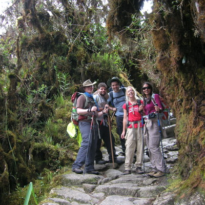 Wandelaars op de Incatrail in Peru, op een stenen pad door dichtbegroeid nevelwoud.