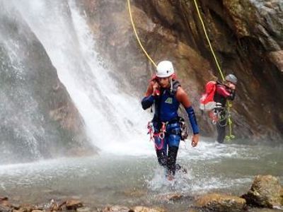 Canyoning in de Mercantour & Vésubie: twee avonturiers dalen langs een waterval af in een rotsachtige kloof.