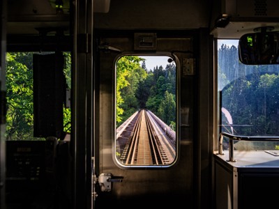 Uitzicht vanuit een trein op spoorrails door groen bos in Japan tijdens de Route Japan.