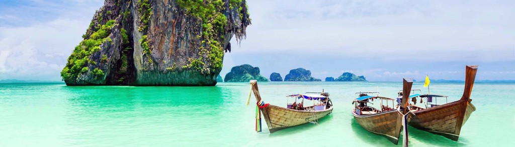 Longtailboten op turquoise zee bij kalkstenen rotsen in Thailand, hoogtepunten van Noord en Zuid.