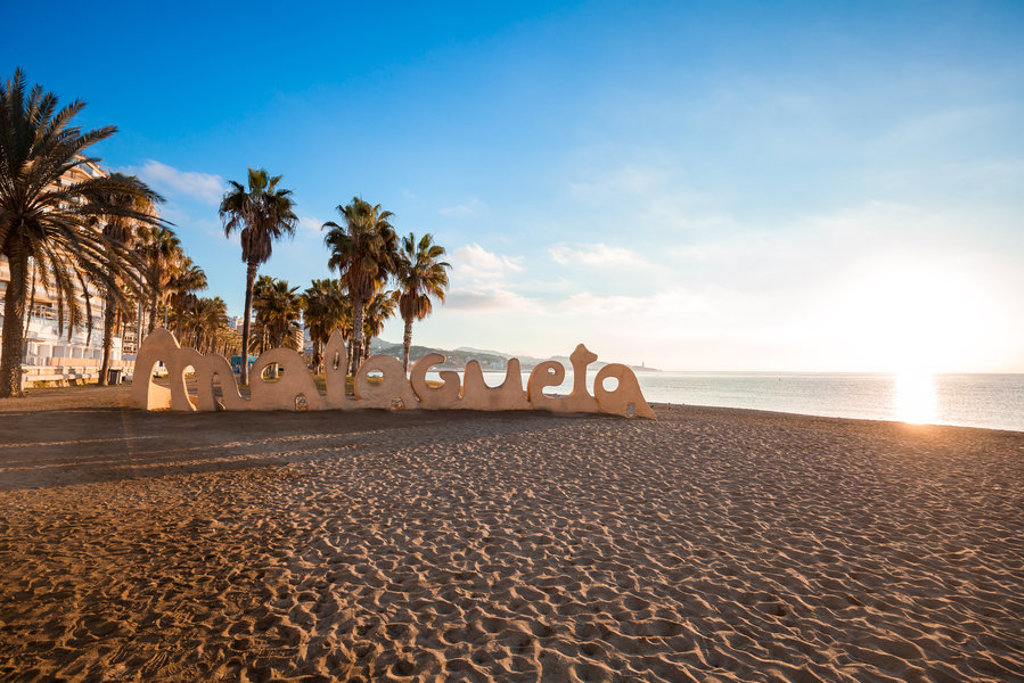 Malagueta-strand in Málaga met palmbomen en het Malagueta-bord bij zonsondergang, familiereis Spanje & Portugal.