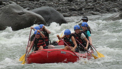 Groep rafters in een rode raft op wildwater in Costa Rica.