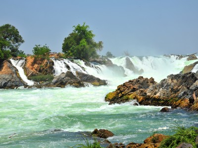 Watervallen en stroomversnellingen tussen rotsen en groen langs de Mekong, Route Laos & Cambodja.