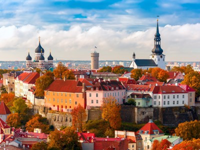 Panorama van de oude binnenstad van Tallinn met kleurrijke daken, kerktorens en herfstbomen in Estland.