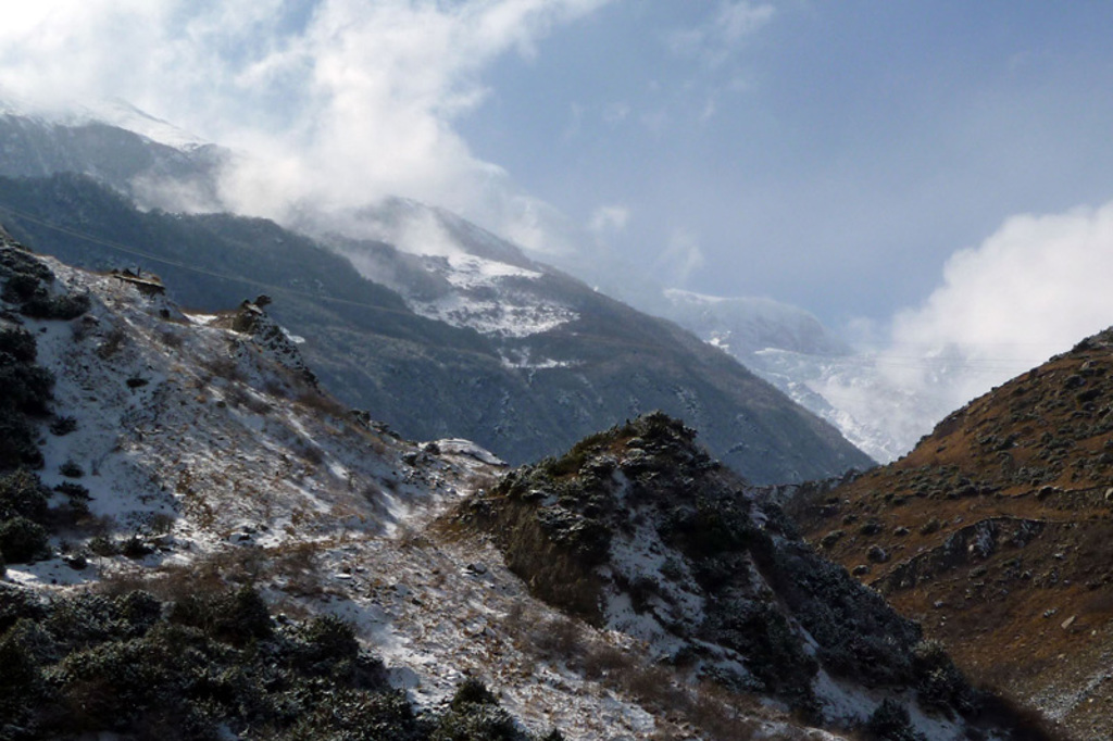 Besneeuwde berghellingen in Armenië met wolken boven de vallei tijdens groepsrondreis Armenië en Georgië.