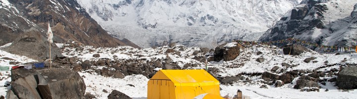 Gele tenten in de sneeuw bij Annapurna Base Camp in Nepal, met uitzicht op besneeuwde Himalayareuzen.