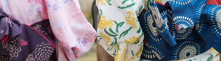 Detail van kleurrijke kimono’s met obi-ceinturen en bloemmotieven.