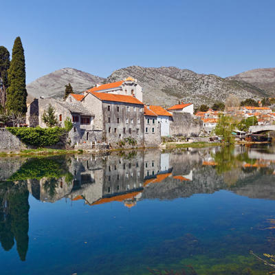 Historisch stadje in Montenegro met stenen brug en roodgedekte huizen, weerspiegeld in de rivier.
