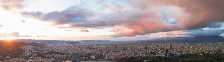 Panoramisch uitzicht over Tirana met stadscentrum en het kunstmatige meer bij zonsondergang.