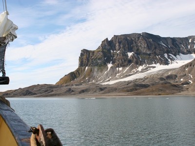 Uitzicht vanaf het zeilschip op ruige bergen en gletsjerkust van Spitsbergen tijdens de route van 10 dagen.