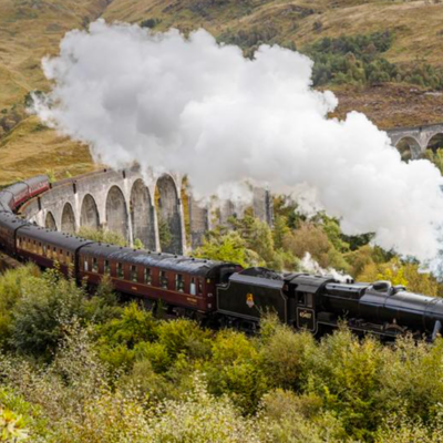 Stoomtrein rijdt over het Glenfinnan-viaduct in de Schotse Hooglanden tijdens een groepsrondreis Schotland.