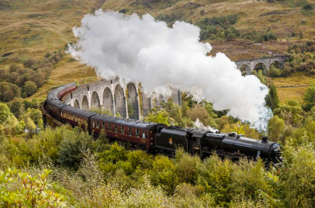 Stoomtrein rijdt over het Glenfinnan-viaduct in de Schotse Hooglanden tijdens een groepsrondreis Schotland.