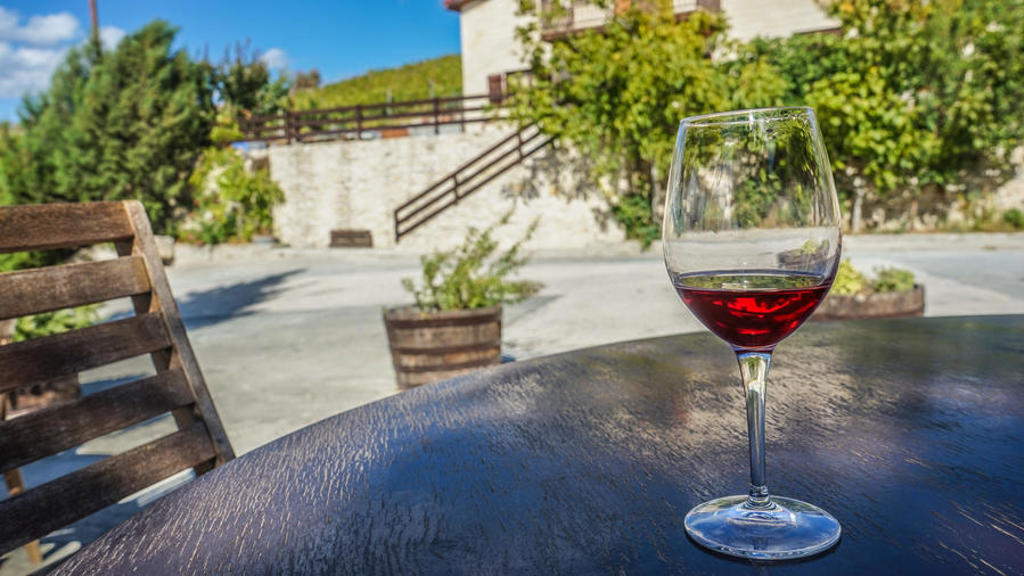Glas Cypriotische rode wijn op een terras in de zon tijdens een familiereis op Cyprus.