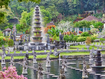 Tirta Gangga-waterpaleis op Bali met fonteinen, vijvers en beelden in een weelderige tuin.