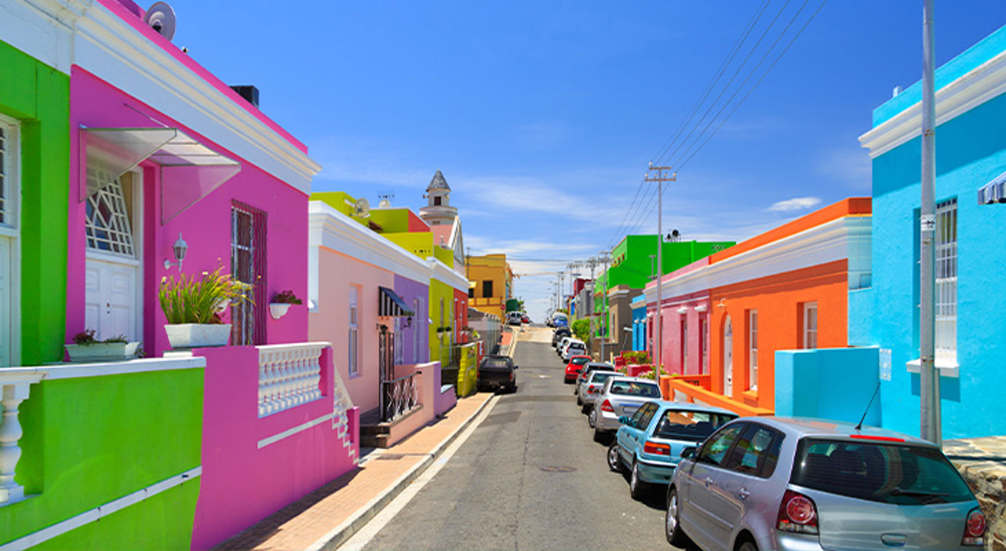 Kleurrijke huizen en geparkeerde auto’s in de wijk Bo-Kaap in Kaapstad, Zuid-Afrika.