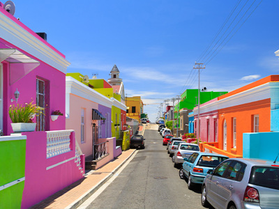 Kleurrijke huizen en geparkeerde auto’s in de wijk Bo-Kaap in Kaapstad, Zuid-Afrika.