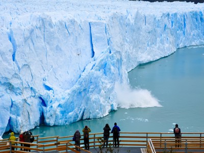 Uitzicht op de Perito Moreno-gletsjer in Argentinië, met reizigers op een uitkijkplatform.