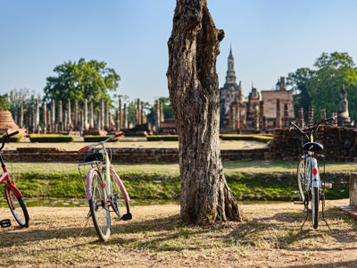Fietsen bij de tempelruïnes van Sukhothai Historical Park in Thailand.