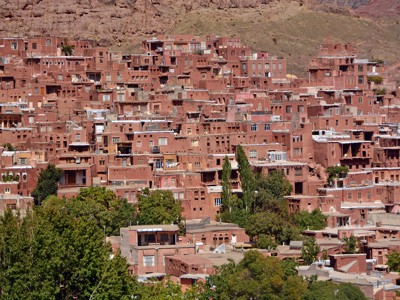 Leemstenen dorp met terrassen tegen een berghelling in Iran tijdens de 19-daagse route.