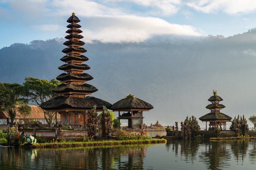 Pura Ulun Danu Bratan-tempel aan het Bratanmeer op Bali, met bergen en wolken op de achtergrond.