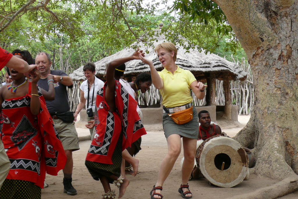 Reizigers dansen mee met lokale dansers bij een traditioneel dorp tijdens groepsrondreis Zuid-Afrika, eSwatini en Lesotho.