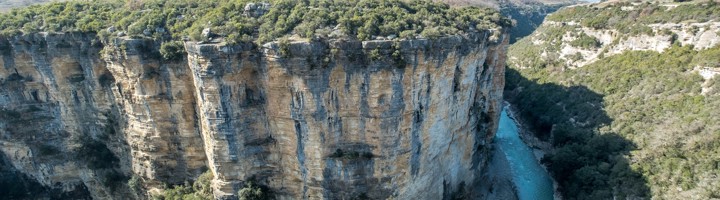 Uitzicht op de Osumi Canyon in Albanië met steile kliffen en de Osum-rivier die door de kloof slingert.