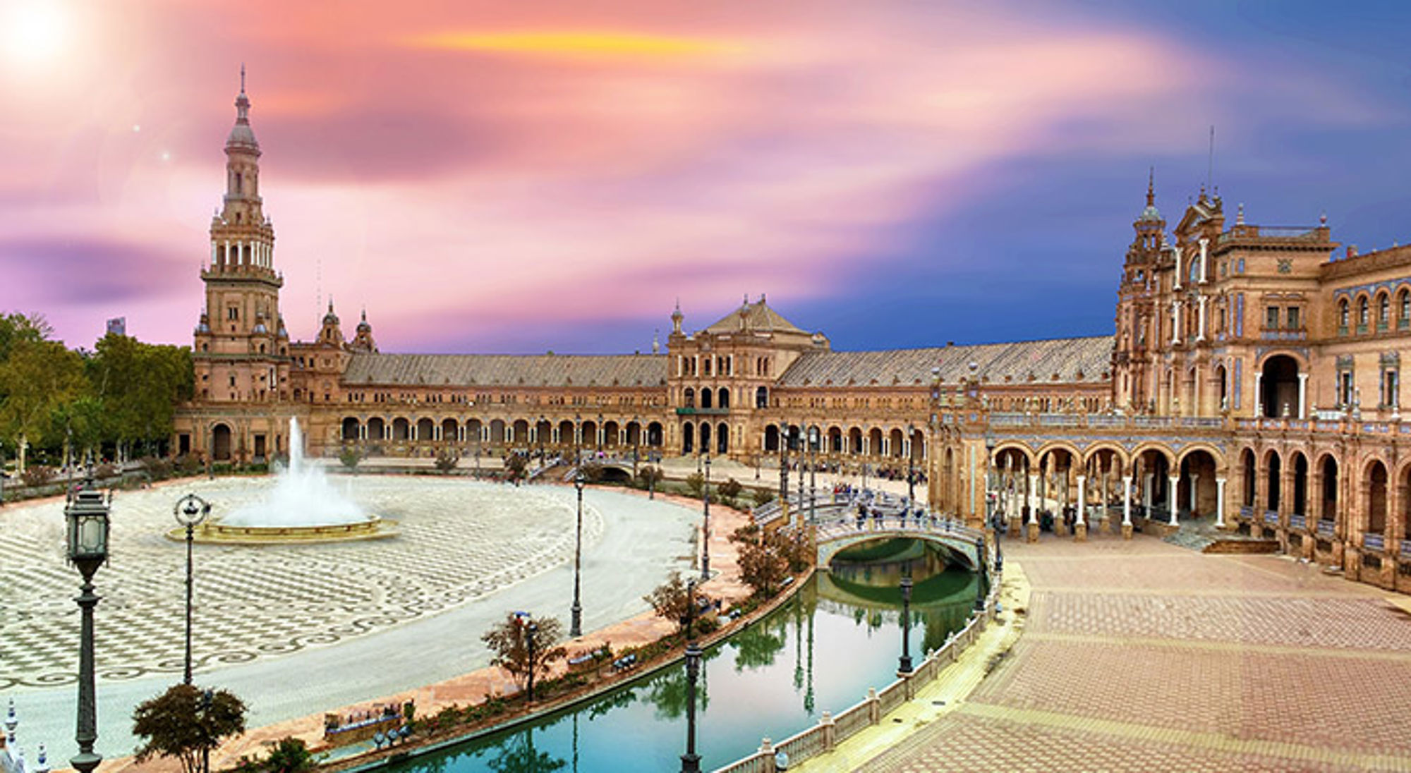 Plein in Sevilla, Spanje Plaza de España in Sevilla met fontein, kanaal en historische gebouwen bij zonsondergang.