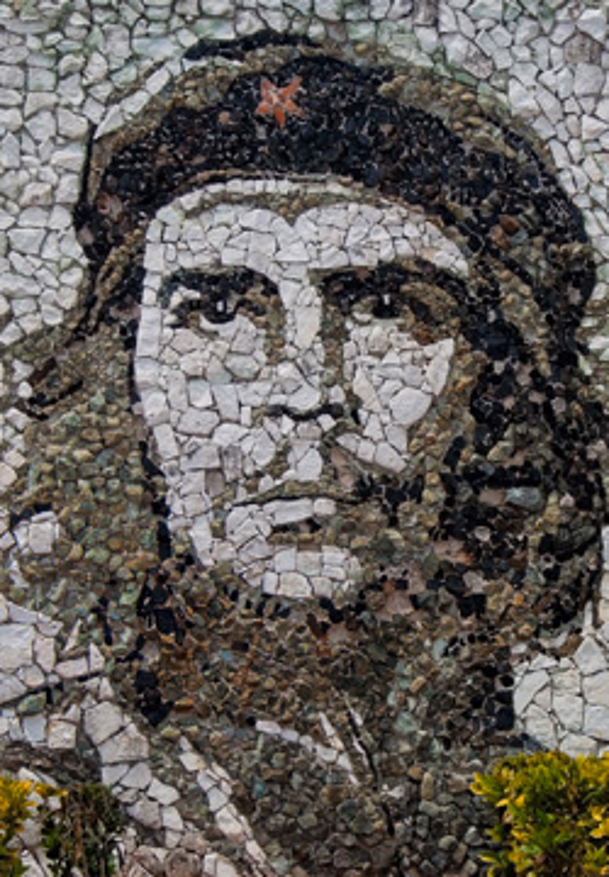 Mozaïekportret van Che Guevara op een stenen muur.