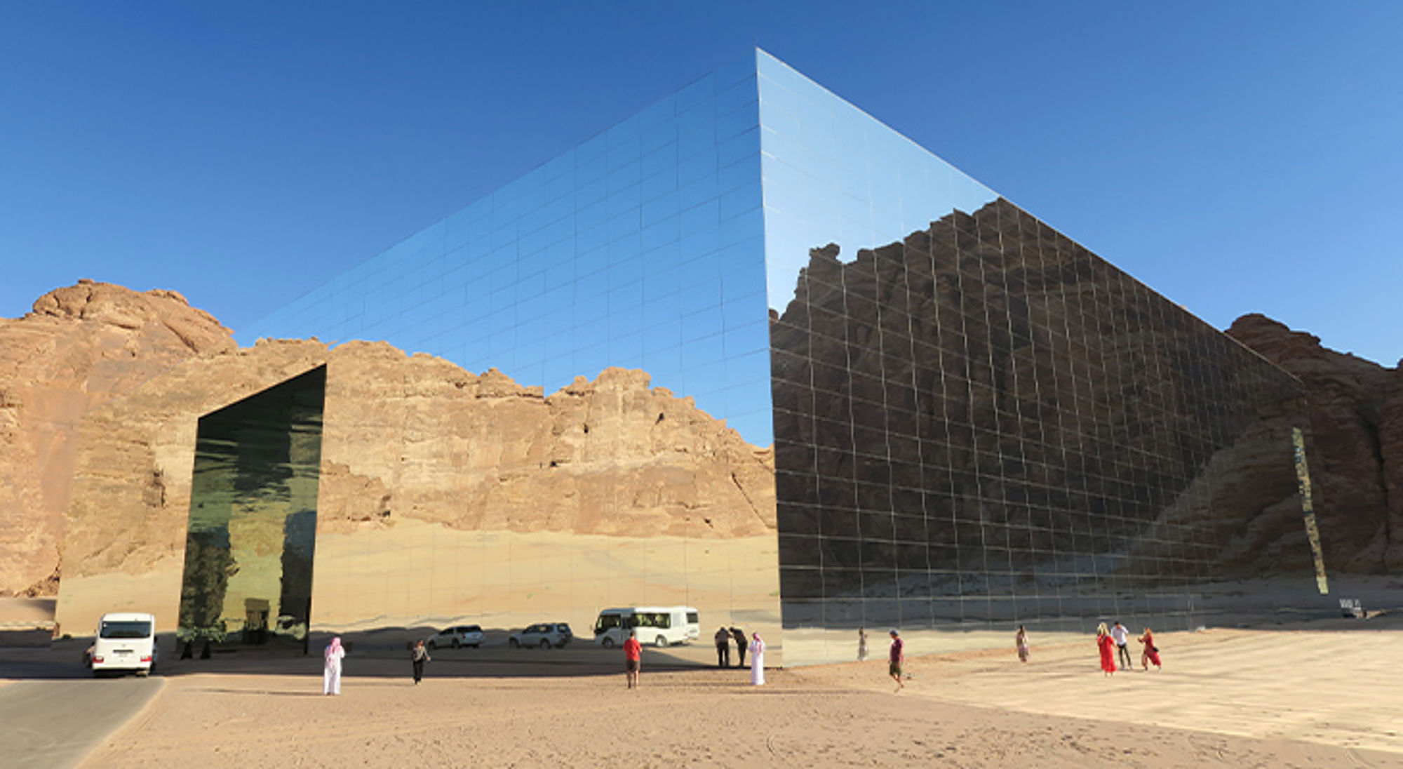 Spiegelend Maraya Concert Hall-gebouw in AlUla, Saoedi-Arabië, met woestijnrotsen op de achtergrond.