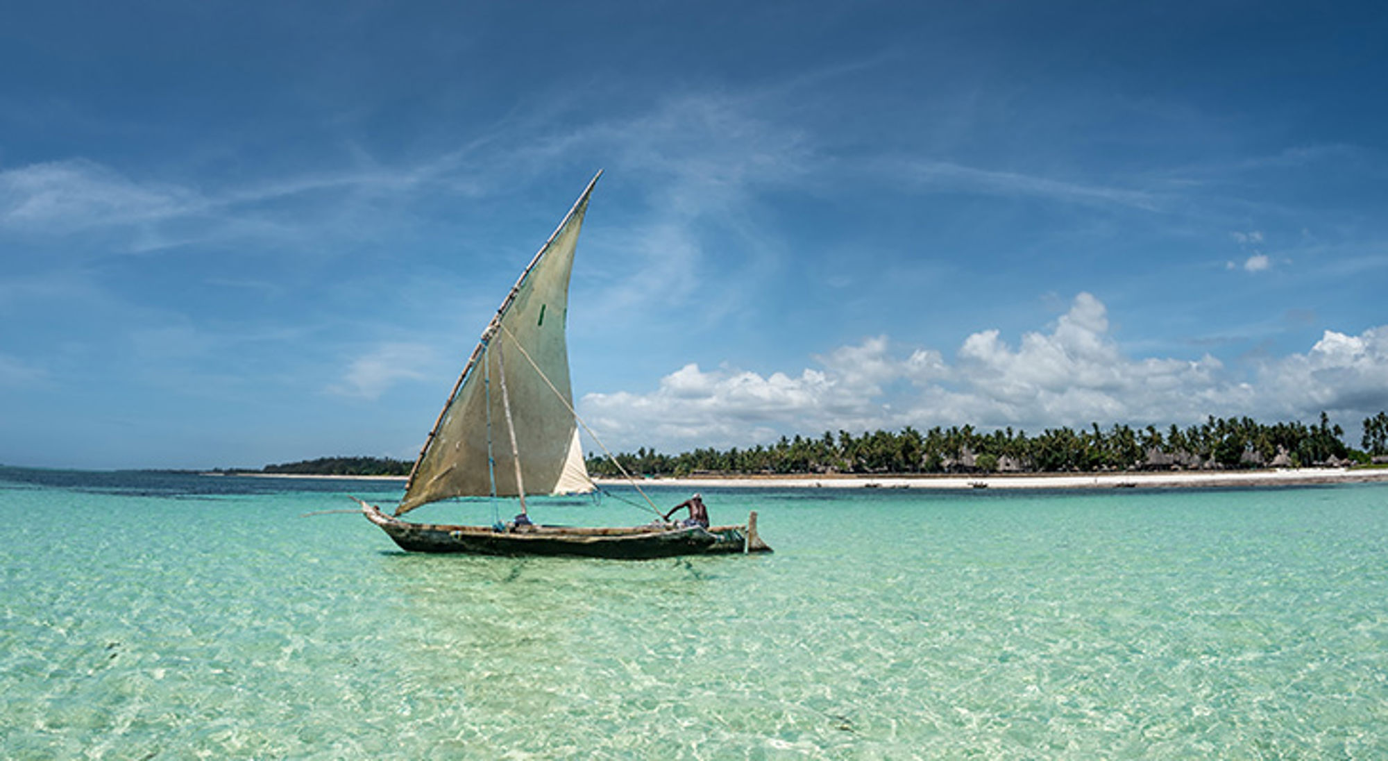 Catamaran in de zee bij Diani Beach Traditionele dhow-zeilboot op turquoise zee bij tropisch strand aan de Keniaanse kust.