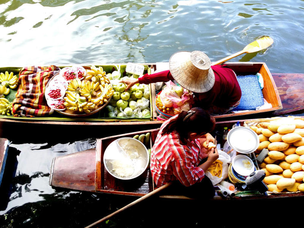 Drijvende markt in Thailand met boten vol fruit, gezien van bovenaf tijdens de familiereis Thailand Hoogtepunten.
