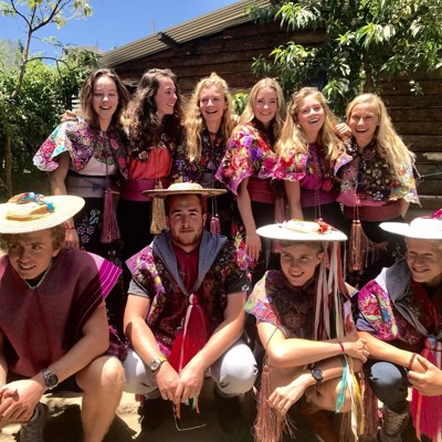 Groep reizigers in kleurrijke Mexicaanse klederdracht tijdens familiereis Mexico hoogtepunten.