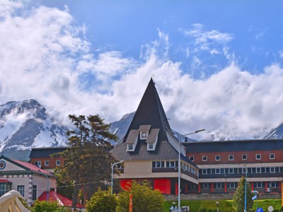 Centrum van Ushuaia met opvallend puntdakgebouw en besneeuwde Andesbergen op de achtergrond.