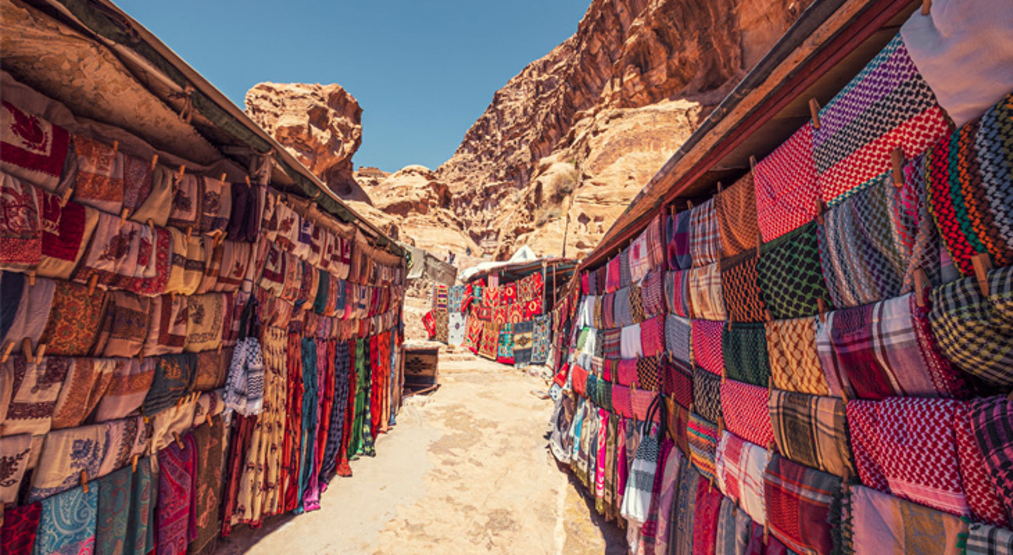 Petra Jordanië Souvenirmarkt met kleurrijke sjaals en doeken tussen de rotsen van Petra, Jordanië.