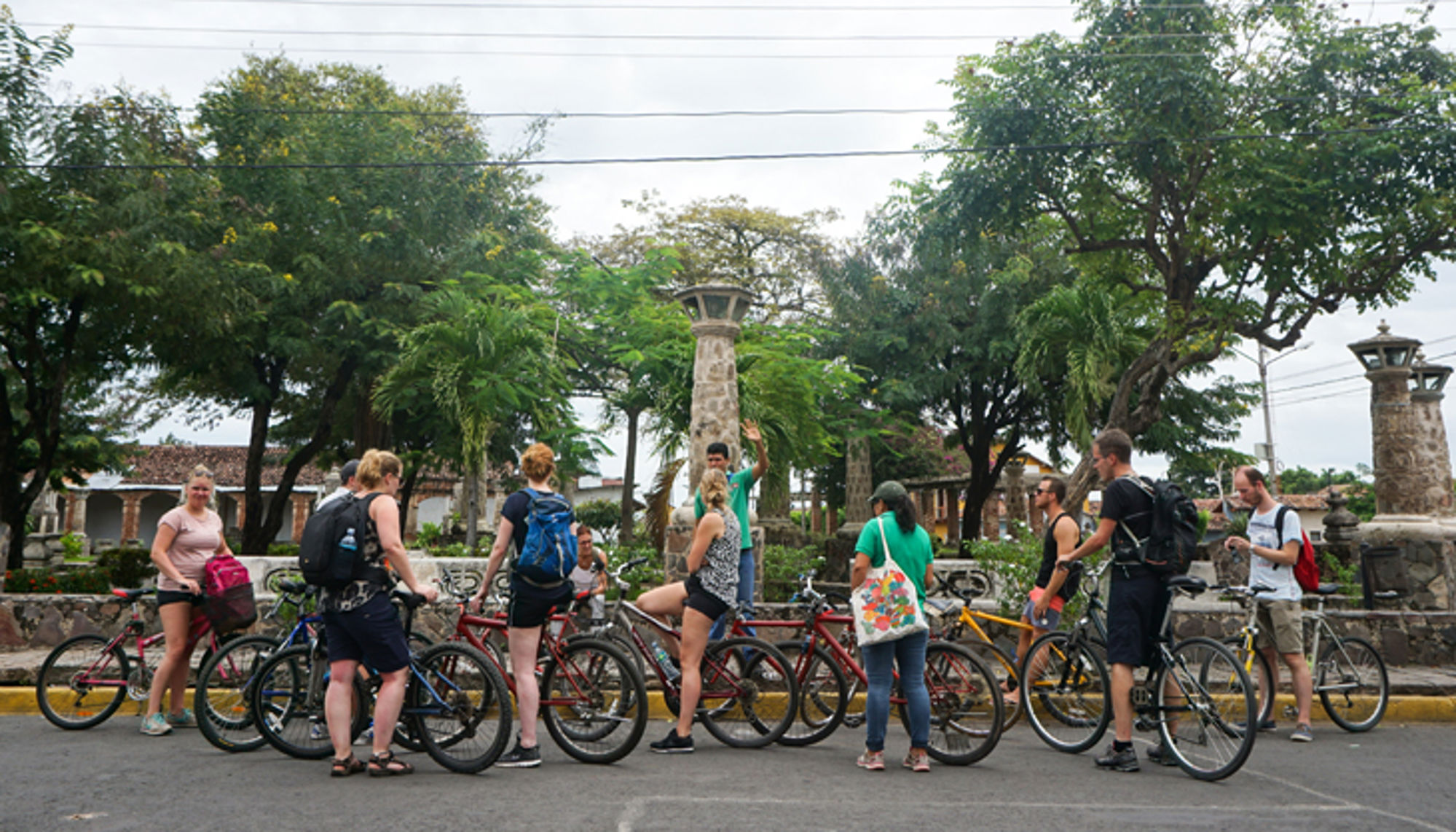 Groep fietsers met gids tijdens een fietstour door een groen stadspark.